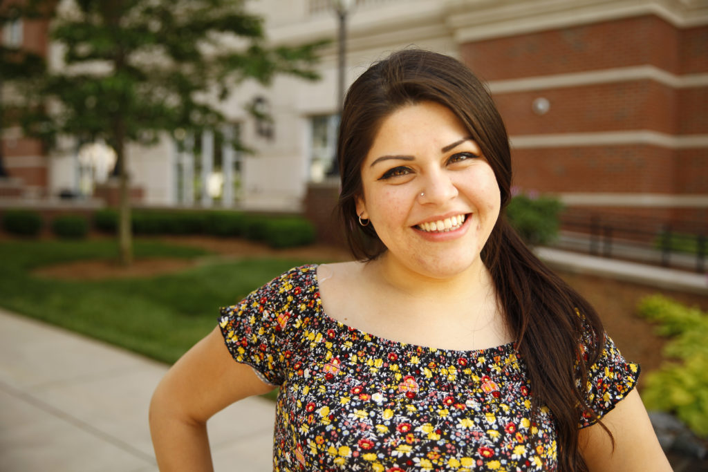 Janessa, smiling, outside of a campus building